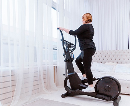 Frau trainiert auf einem Crosstrainer