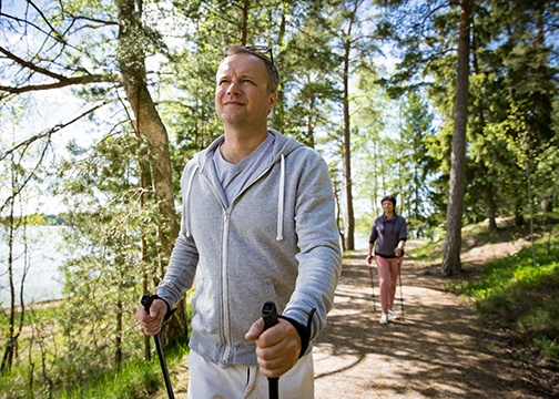 Mann und Frau machen Nordic Walking im Wald