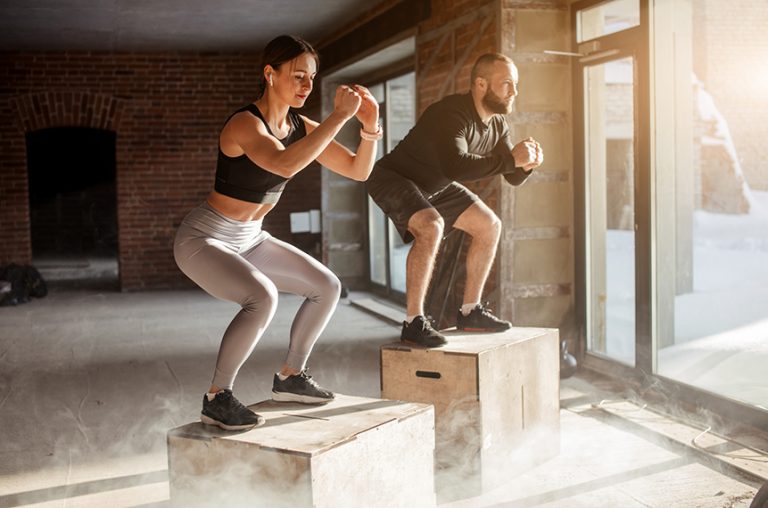 Mann und Frau springen auf Plyoboxen