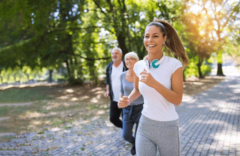 Frau geht gemeinsam mit zwei älteren Personen im Park laufen